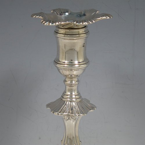 An Antique Georgian cast Sterling Silver pair of George II candlesticks, having baluster bodies, with six-shell bases, and removable nozzles. Made by John Cafe of London in 1754. The dimensions of this fine pair of hand-made antique silver candlesticks are height 22 cms (8.75 inches), width at base 13 cms (5.25 inches), and they weigh a total of 1,106g (35.7 troy ounces). Please note that these items are part-crested.