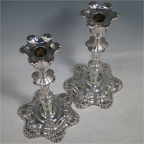 An Antique Georgian cast Sterling Silver pair of George II candlesticks, having baluster bodies, with six-shell bases, and removable nozzles. Made by John Cafe of London in 1754. The dimensions of this fine pair of hand-made antique silver candlesticks are height 22 cms (8.75 inches), width at base 13 cms (5.25 inches), and they weigh a total of 1,106g (35.7 troy ounces). Please note that these items are part-crested.