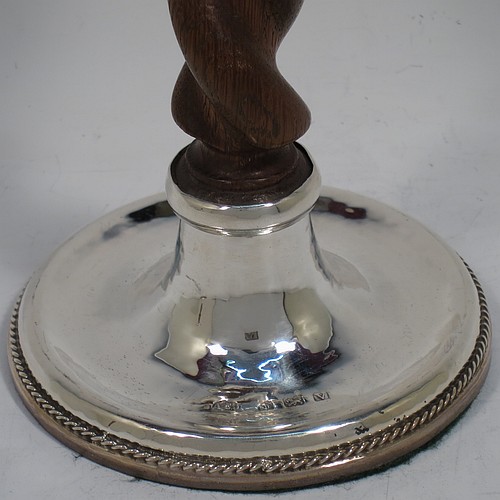 A very unusual and pretty Sterling Silver pair of Arts and Crafts candlesticks, having round bases with a hand-hammered finish and applied rope-twist lower borders, with hand-carved wooden swirl columns, and round capitals with deep drip pans. Made by A. E. Jones of Birmingham in 1920. The dimensions of these fine hand-made Arts and Crafts silver candlesticks are height 17 cms (6.75 inches), and diameter at base 10 cms (4 inches).