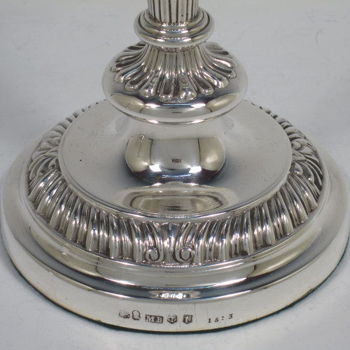 A very handsome pair of Antique Georgian Regency Sterling Silver candlesticks, having hand-chased fluted decoration and applied gadroon and shell borders, with their original removable nozzles, and round pedestal bases. Made by Matthew Boulton of Birmingham in 1817. The dimensions of this fine hand-made pair of antique silver candlesticks are height 23.5 cms (9.25 inches), and diameter of bases 12 cms (4.75 inches).