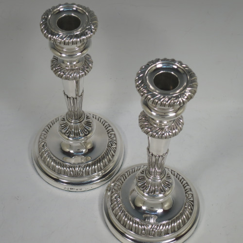 A very handsome pair of Antique Georgian Regency Sterling Silver candlesticks, having hand-chased fluted decoration and applied gadroon and shell borders, with their original removable nozzles, and round pedestal bases. Made by Matthew Boulton of Birmingham in 1817. The dimensions of this fine hand-made pair of antique silver candlesticks are height 23.5 cms (9.25 inches), and diameter of bases 12 cms (4.75 inches).
