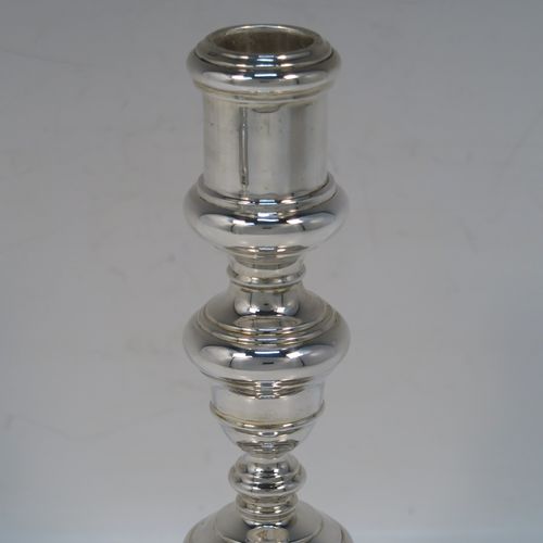 A very elegant pair of cast Sterling Silver candlesticks in a George I style, having plain round baluster bodies, and sitting on plain octagonal bases. These handsome silver candlesticks were made by Goldsmiths and Silversmiths of Sheffield in 1931. The dimensions of this fine pair of hand-made silver table candlesticks are height 19 cms (7.5 inches), the bases are 12.5 cms (5 inches) square, and the total weight is 805g (26 troy ounces)