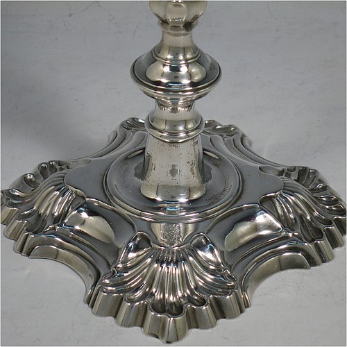 An Antique Georgian cast Sterling Silver pair of George II candlesticks, having baluster bodies, with four-shell bases, and removable nozzles. Made by Dorothy Sarbett of London in 1754. The dimensions of this fine pair of hand-made antique silver candlesticks are height 20 cms (8 inches), width at base 11 cms (4.25 inches), and they weigh a total of 965g (31 troy ounces). Please note that these items are part-crested.