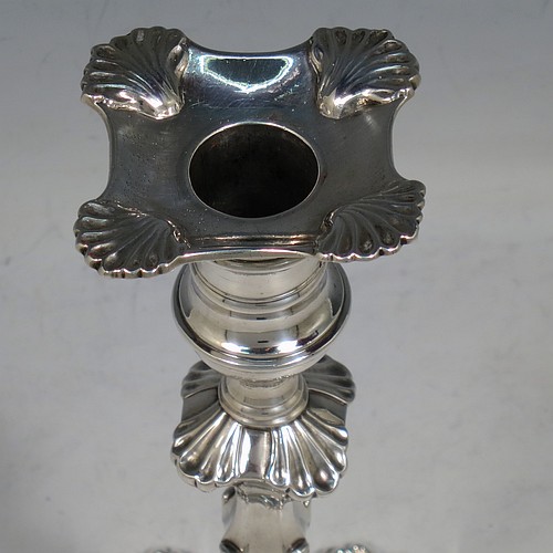 An Antique Georgian cast Sterling Silver pair of George II candlesticks, having baluster bodies, with four-shell bases, and removable nozzles. Made by Dorothy Sarbett of London in 1754. The dimensions of this fine pair of hand-made antique silver candlesticks are height 20 cms (8 inches), width at base 11 cms (4.25 inches), and they weigh a total of 965g (31 troy ounces). Please note that these items are part-crested.