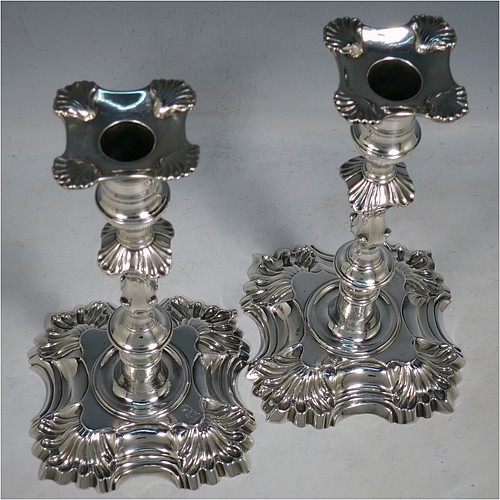 An Antique Georgian cast Sterling Silver pair of George II candlesticks, having baluster bodies, with four-shell bases, and removable nozzles. Made by Dorothy Sarbett of London in 1754. The dimensions of this fine pair of hand-made antique silver candlesticks are height 20 cms (8 inches), width at base 11 cms (4.25 inches), and they weigh a total of 965g (31 troy ounces). Please note that these items are part-crested.