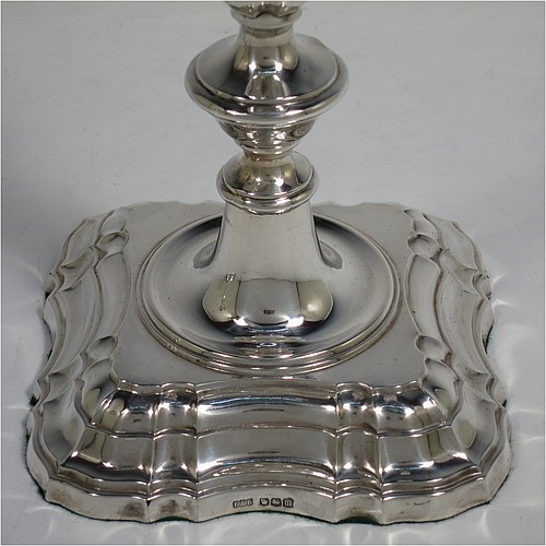 A handsome Sterling Silver pair of candlesticks in the George II four-shell corner style, having baluster bodies, with shaped square bases and shell corners, fluted baluster columns, and removable nozzles. Made by F & F of Sheffield in 1927. The dimensions of these fine hand-made silver candlesticks are height 24 cms (9.5 inches), and base 11 cms (4.25 inches) square.