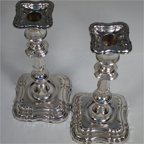 A handsome Sterling Silver pair of candlesticks in the George II four-shell corner style, having baluster bodies, with shaped square bases and shell corners, fluted baluster columns, and removable nozzles. Made by F & F of Sheffield in 1927. The dimensions of these fine hand-made silver candlesticks are height 24 cms (9.5 inches), and base 11 cms (4.25 inches) square.