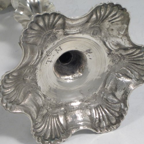 Antique Georgian cast sterling silver pair of George II candlesticks, having baluster bodies, with six-shell bases, and removable nozzles. Made by John Cafe of London in 1751/52. The dimensions of this fine pair of hand-made silver candlesticks are height 21.5 cms (8.5 inches), width at base 13 cms (5.25 inches), and they weigh a total of 1,054g (34 troy ounces).