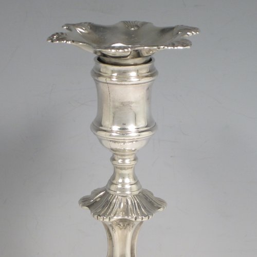 Antique Georgian cast sterling silver pair of George II candlesticks, having baluster bodies, with six-shell bases, and removable nozzles. Made by John Cafe of London in 1751/52. The dimensions of this fine pair of hand-made silver candlesticks are height 21.5 cms (8.5 inches), width at base 13 cms (5.25 inches), and they weigh a total of 1,054g (34 troy ounces).