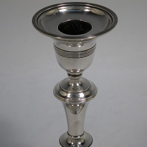 A very handsome Antique Edwardian Sterling Silver pair of candlesticks, in a very plain round style, having baluster bodies with hand-chased reeded borders, and original removable nozzles. Made by William Comyns of London in 1904. The dimensions of these fine hand-made antique silver candlesticks are height 15 cms (6 inches), and the bases are 10 cms (4 inches) in diameter.