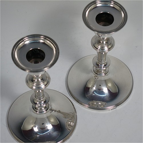 A very handsome Antique Edwardian Sterling Silver pair of candlesticks, in a very plain round style, having baluster bodies with hand-chased reeded borders, and original removable nozzles. Made by William Comyns of London in 1904. The dimensions of these fine hand-made antique silver candlesticks are height 15 cms (6 inches), and the bases are 10 cms (4 inches) in diameter.