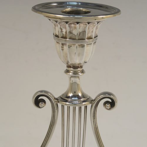 An unusual and pretty Antique Victorian Sterling Silver pair of candlesticks, having Lyre harp musical instrument style bodies, with fluted and reeded decoration, removable nozzles, and sitting on oval bases. This beautiful pair of Lyre Harp candlesticks were made by George Hancock of London in 1901. The dimensions of these fine hand-made pair of antique silver candlesticks are height 20.5 cms (8 inches), and width at base 11.5 cms (4.5 inches).   