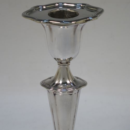 A handsome pair of Antique Edwardian Sterling Silver candlesticks, having Neoclassical style oval shaped bodies, with hand-chased fluted decoration, reeded borders, and removable nozzles. Made by Hawksworth Eyre and Co., of Sheffield in 1902. The dimensions of these fine hand-made pair of antique silver table candlesticks are height 18 cms (7 inches), length at base 10 cms (4 inches), and width at base 8 cms (3.25 inches).