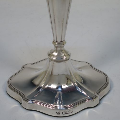 A handsome pair of Antique Edwardian Sterling Silver candlesticks, having Neoclassical style oval shaped bodies, with hand-chased fluted decoration, reeded borders, and removable nozzles. Made by Hawksworth Eyre and Co., of Sheffield in 1902. The dimensions of these fine hand-made pair of antique silver table candlesticks are height 18 cms (7 inches), length at base 10 cms (4 inches), and width at base 8 cms (3.25 inches).