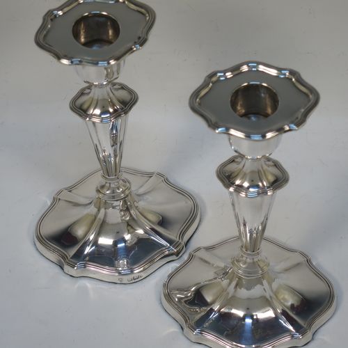 A handsome pair of Antique Edwardian Sterling Silver candlesticks, having Neoclassical style oval shaped bodies, with hand-chased fluted decoration, reeded borders, and removable nozzles. Made by Hawksworth Eyre and Co., of Sheffield in 1902. The dimensions of these fine hand-made pair of antique silver table candlesticks are height 18 cms (7 inches), length at base 10 cms (4 inches), and width at base 8 cms (3.25 inches).