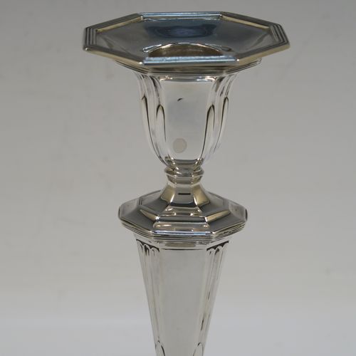 A very elegant Antique Victorian Sterling Silver pair of candlesticks, having octagonal bodies with hand-chased fluted decoration, reed-edged borders, and removable nozzles. These handsome antique silver candlesticks were made by Martin & Hall of Sheffield in 1901. The dimensions of these fine hand-made antique silver candlesticks are height 18.5 cms (7.25 inches), and the bases are 10 cms (4 inches) long, by 8 cms (3 inches) wide.
