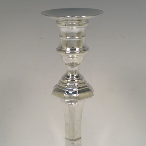 A handsome and bold pair of Sterling Silver candlesticks in a George I style, having octagonal baluster bodies, with round removable round nozzles, and sitting on cut-corner square bases. These elegant silver candlesticks were made by Garrard and Co., of Birmingham in 1984. The dimensions of these fine hand-made silver table candlesticks are height 24 cms (9.5 inches), and the bases are 14 cms (5.5 inches) square.   