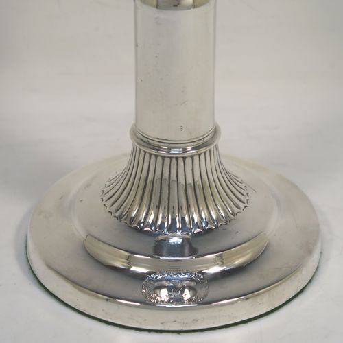 A very handsome and rare pair of Antique Georgian Sterling Silver telescopic candlesticks, having round straight-sided columns, with fluted decoration round the tops and bases, and removable nozzles. These elegant antique silver telescopic candlesticks were made by George Ashfoed and Co., of Sheffield in 1800. The dimensions of these fine hand-made antique silver telescopic candlesticks are height collapsed 18 cms (5 inches), extended 27 cms (10.5 inches), and the diameter of the bases are 11.5 cms (4.5 inches). Please note that these items are part crested. 