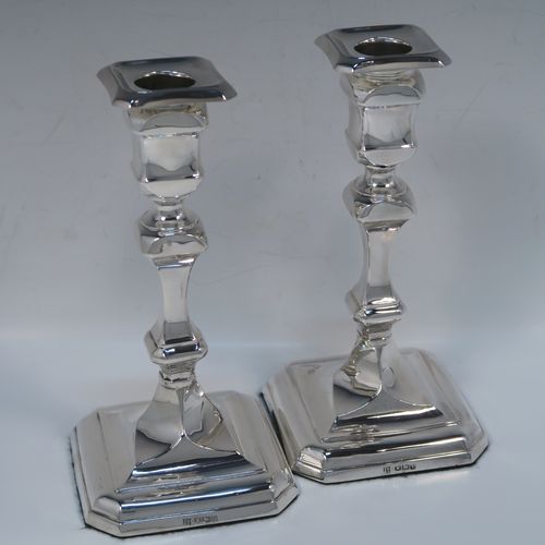 A handsome and bold pair of Sterling Silver candlesticks in a George I style, having cut-corner square baluster bodies, with removable nozzles, and sitting on cut-corner square bases. These elegant silver candlesticks were made by Thomas Bradbury of Sheffield in 1928. The dimensions of these fine hand-made silver table candlesticks are height 18 cms (7 inches), and the bases are 9 cms (3.5 inches) square.  