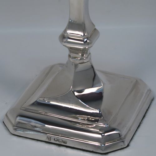 A handsome and bold pair of Sterling Silver candlesticks in a George I style, having cut-corner square baluster bodies, with removable nozzles, and sitting on cut-corner square bases. These elegant silver candlesticks were made by Thomas Bradbury of Sheffield in 1928. The dimensions of these fine hand-made silver table candlesticks are height 18 cms (7 inches), and the bases are 9 cms (3.5 inches) square.