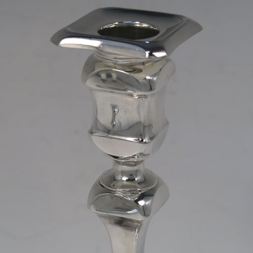 A handsome and bold pair of Sterling Silver candlesticks in a George I style, having cut-corner square baluster bodies, with removable nozzles, and sitting on cut-corner square bases. These elegant silver candlesticks were made by Thomas Bradbury of Sheffield in 1928. The dimensions of these fine hand-made silver table candlesticks are height 18 cms (7 inches), and the bases are 9 cms (3.5 inches) square.