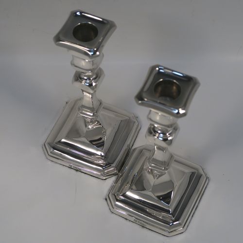 A handsome and bold pair of Sterling Silver candlesticks in a George I style, having cut-corner square baluster bodies, with removable nozzles, and sitting on cut-corner square bases. These elegant silver candlesticks were made by Thomas Bradbury of Sheffield in 1928. The dimensions of these fine hand-made silver table candlesticks are height 18 cms (7 inches), and the bases are 9 cms (3.5 inches) square.