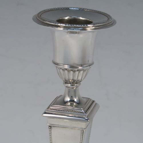 A very handsome Antique Sterling silver pair of table candlesticks, in a Neoclassical style, having square cross-section bodies with applied bead-edged borders, tapering columns, and removable nozzles. These elegant silver candlesticks were made by Thomas Scott of Sheffield in 1912. The dimensions of these fine hand-made antique silver candlesticks are height 20.5 cms (8 inches), and 9 cms (3.5 inches) square at bases.