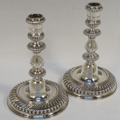 A very handsome pair of cast Britannia standard Silver candlesticks in an early Queen Ann style, having round baluster bodies with applied and hand-chased fluted borders. These elegant cast silver candlesticks were made by Wakely and Wheeler of London in 1967. The dimensions of this fine pair of hand-made cast sterling silver table candlesticks are height 17 cms (6.75 inches), the bases are 11 cms (4.25 inches) in diameter, and the total weight is 871g (28 troy ounces).   
