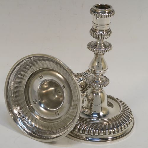 A very handsome pair of cast Britannia standard Silver candlesticks in an early Queen Ann style, having round baluster bodies with applied and hand-chased fluted borders. These elegant cast silver candlesticks were made by Wakely and Wheeler of London in 1967. The dimensions of this fine pair of hand-made cast sterling silver table candlesticks are height 17 cms (6.75 inches), the bases are 11 cms (4.25 inches) in diameter, and the total weight is 871g (28 troy ounces).