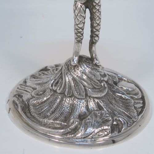 A very unusual pair of cast Sterling Silver Harlequin candlesticks, having round nozzles with drip pans, Harlequin model shaped columns, and sitting on hand-chased floral and scroll bases. These unique cast silver candlesticks were made by A. Haviland-Nye of London in 1979. The dimensions of this fine pair of hand-made cast Harlequin model sterling silver table candlesticks are height 13 cms (5 inches), the bases are 6.5 cms (2.5 inches) in diameter, and the total weight is 298g (9.6 troy ounces).