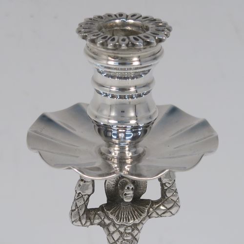 A very unusual pair of cast Sterling Silver Harlequin candlesticks, having round nozzles with drip pans, Harlequin model shaped columns, and sitting on hand-chased floral and scroll bases. These unique cast silver candlesticks were made by A. Haviland-Nye of London in 1979. The dimensions of this fine pair of hand-made cast Harlequin model sterling silver table candlesticks are height 13 cms (5 inches), the bases are 6.5 cms (2.5 inches) in diameter, and the total weight is 298g (9.6 troy ounces).