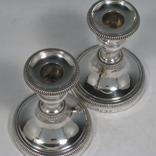 Antique Georgian sterling silver pair of candlesticks, having round bases with baluster bodies, gadroon borders, and removable nozzles. Made by James Roberts and Co., of Sheffield in 1809. The dimensions of these fine hand-made silver candlesticks are height 12.5 cms (5 inches), and the diameter of the bases are 9.5 cms (3.75 inches).