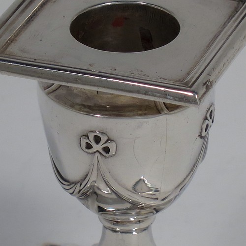 An Antique Victorian Sterling Silver very pretty pair of small candlesticks, having neoclassical style decoration with rectangular bases, with hand-chased bows and swags, and removable nozzles with applied reeded borders. Made by William Angus Fraser of Sheffield in 1894. The dimensions of these fine hand-made antique silver candlesticks are height 8 cms (3.25 inches), and the bases are 7 cms (2.75 inches) square.