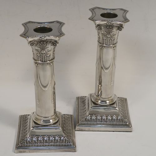 A very pretty Antique Edwardian Sterling Silver pair of candlesticks, in a Neoclassical style with hand-chased bows, swags, and acanthus leaves, with bead-edged borders, removable nozzles, and square bases. This beautiful pair of antique silver candlesticks were made by Thomas Scot of Sheffield in 1908. The dimensions of this fine pair of hand-made antique silver candlesticks are height 16 cms (6.3 inches), and the bases are 8 cms (3.25 inches) square.   
