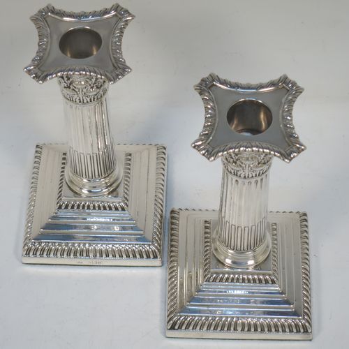 A very pretty pair of Antique Victorian Sterling Silver of Corinthian style candlesticks, having traditional gadroon borders, acanthus-leaf capitals, fluted columns, removable nozzles, and square stepped bases. Made by William Hutton of London in 1901. The dimensions of this fine hand-made pair of antique silver candlesticks are height 16 cms (6.25 inches), and the bases are 8.5 cms (3.3 inches) square.