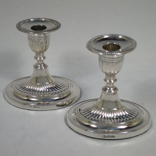 A very pretty pair of Antique Edwardian Sterling Silver candlesticks, having oval bodies with hand-chased half-fluted decoration, original removable nozzles with applied leaf-style borders. Made by Fordham and Faulkner of Sheffield in 1906. The dimensions of these fine hand-made antique silver candlesticks are height 11 cms (4.25 inches), and the bases are 11 cms (4.25 inches) long.    
