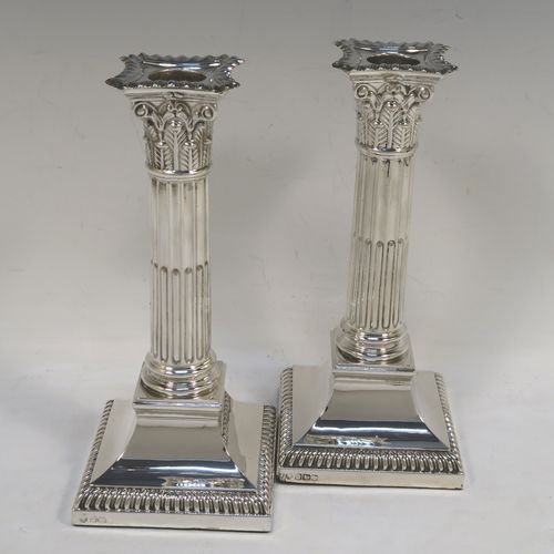 A very handsome and bold pair of Sterling Silver of Corinthian style candlesticks, having traditional gadroon borders, acanthus-leaf capitals, fluted columns, removable nozzles, and square stepped bases. These beautiful silver candlesticks were made by Hawksworth Eyre and Co., of Sheffield in 1923. The dimensions of this fine hand-made pair of silver candlesticks are height 19.5 cms (7.75 inches), and the bases are 8.5 cms (3.3 inches) square.   
