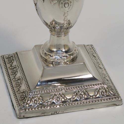 A very pretty pair of Antique Victorian Sterling Silver candlesticks, having urn-shaped bodies sitting on square pedestal bases, with hand-chased neoclassical style decoration, bead-edged borders, and removable nozzles. These beautiful antique silver candlesticks were made by Charles Boyton of London in 1892. The dimensions of these fine hand-made silver candlesticks are height 11 cms (4.3 inches), and the bases are 8.5 cms (3.3 inches) square.

  