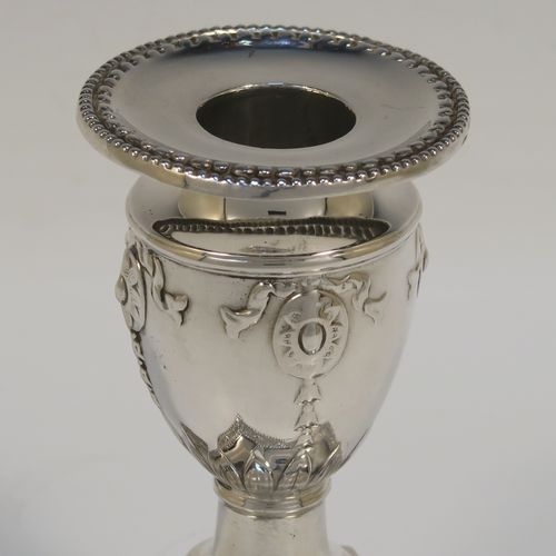 A very pretty pair of Antique Victorian Sterling Silver candlesticks, having urn-shaped bodies sitting on square pedestal bases, with hand-chased neoclassical style decoration, bead-edged borders, and removable nozzles. These beautiful antique silver candlesticks were made by Charles Boyton of London in 1892. The dimensions of these fine hand-made silver candlesticks are height 11 cms (4.3 inches), and the bases are 8.5 cms (3.3 inches) square.

  
