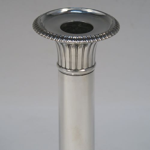 A very handsome pair of Antique Georgian Sterling Silver candlesticks, having round bases with plain straight columns, with hand-chased fluted decoration and gadroon borders to the removable nozzles. These elegant antique silver candlesticks were made by John Roberts of Sheffield in 1808. The dimensions of these fine hand-made antique Georgian silver candlesticks are height 17 cms (6.75 inches), and the bases are 11 cms (4.3 inches) in diameter.