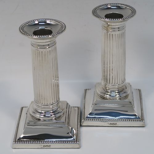 A very elegant Antique Sterling Silver pair of candlesticks, in a Neoclassical style, having fluted round columns, and with bead-edged borders, removable nozzles, and square bases. This handsome pair of antique silver candlesticks were made by Martin Hall and Co., of Sheffield in 1911. The dimensions of this fine pair of hand-made antique silver candlesticks are height 14 cms (5.5 inches), and the bases are 8 cms (3.25 inches) square.   