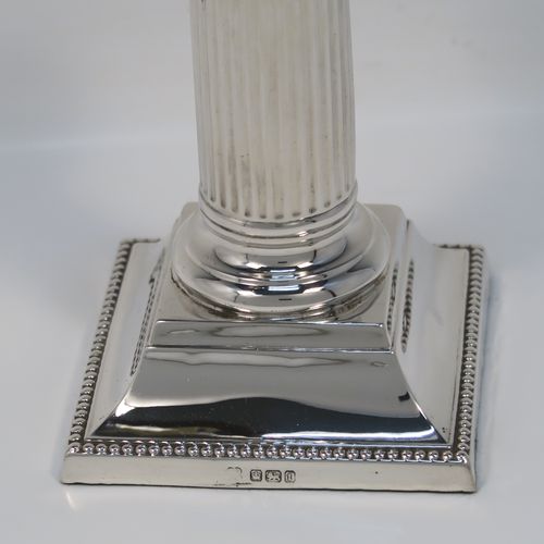 A very elegant Antique Sterling Silver pair of candlesticks, in a Neoclassical style, having fluted round columns, and with bead-edged borders, removable nozzles, and square bases. This handsome pair of antique silver candlesticks were made by Martin Hall and Co., of Sheffield in 1911. The dimensions of this fine pair of hand-made antique silver candlesticks are height 14 cms (5.5 inches), and the bases are 8 cms (3.25 inches) square.   