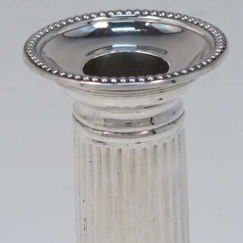 A very elegant Antique Sterling Silver pair of candlesticks, in a Neoclassical style, having fluted round columns, and with bead-edged borders, removable nozzles, and square bases. This handsome pair of antique silver candlesticks were made by Martin Hall and Co., of Sheffield in 1911. The dimensions of this fine pair of hand-made antique silver candlesticks are height 14 cms (5.5 inches), and the bases are 8 cms (3.25 inches) square.   