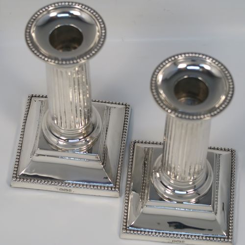 A very elegant Antique Sterling Silver pair of candlesticks, in a Neoclassical style, having fluted round columns, and with bead-edged borders, removable nozzles, and square bases. This handsome pair of antique silver candlesticks were made by Martin Hall and Co., of Sheffield in 1911. The dimensions of this fine pair of hand-made antique silver candlesticks are height 14 cms (5.5 inches), and the bases are 8 cms (3.25 inches) square.   