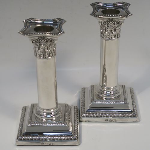 A very handsome Antique Edwardian Sterling Silver pair of candlesticks, in a Neoclassical Corinthian style, having plain round columns, and with gadroon-edged borders, removable nozzles, and square bases. This beautiful pair of antique silver candlesticks were made by William Hutton and Sons of London in 1905. The dimensions of this fine pair of hand-made antique silver candlesticks are height 14 cms (5.5 inches), and the bases are 7.5 cms (3 inches) square.   