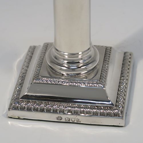 A very handsome Antique Edwardian Sterling Silver pair of candlesticks, in a Neoclassical Corinthian style, having plain round columns, and with gadroon-edged borders, removable nozzles, and square bases. This beautiful pair of antique silver candlesticks were made by William Hutton and Sons of London in 1905. The dimensions of this fine pair of hand-made antique silver candlesticks are height 14 cms (5.5 inches), and the bases are 7.5 cms (3 inches) square.   