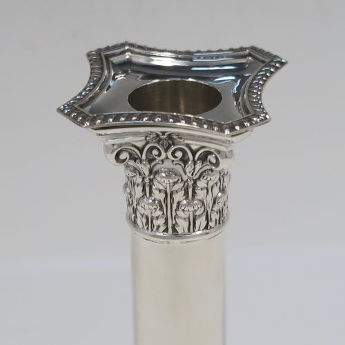 A very handsome Antique Edwardian Sterling Silver pair of candlesticks, in a Neoclassical Corinthian style, having plain round columns, and with gadroon-edged borders, removable nozzles, and square bases. This beautiful pair of antique silver candlesticks were made by William Hutton and Sons of London in 1905. The dimensions of this fine pair of hand-made antique silver candlesticks are height 14 cms (5.5 inches), and the bases are 7.5 cms (3 inches) square.   