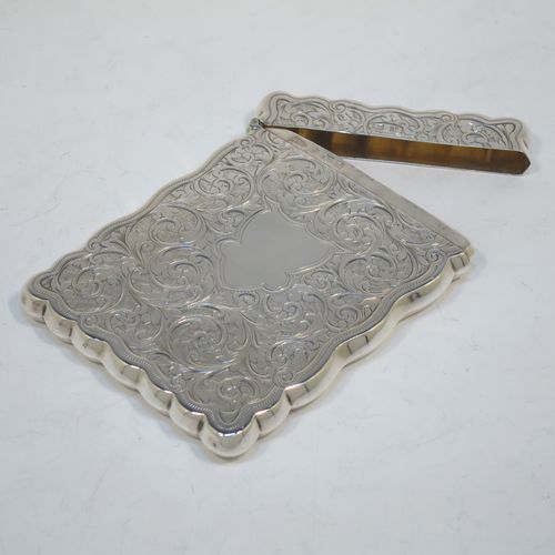 A very elegant Antique Victorian Sterling Silver calling card case, having a shaped rectangular body with hand-engraved floral and scroll decoration, a gold-gilt interior, a vacant central cartouche on one side, and a side-hinged lid. Made by Walker and Hall of Birmingham in 1900. The dimensions of this fine hand-made antique silver card case are length 9.5 cms (3.75 inches), width 7 cms (2.75 inches), and it weighs approx. 74g (2.4 troy ounces).