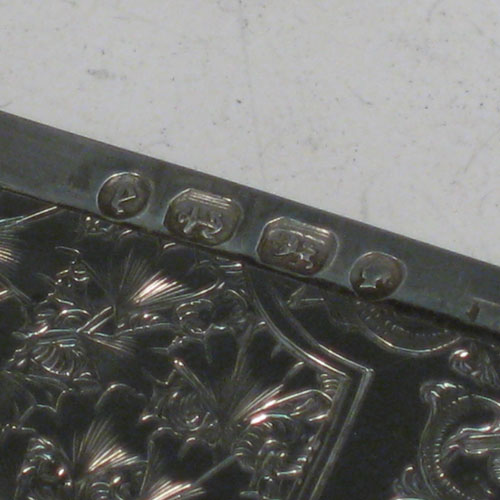 Antique Victorian sterling silver calling card case, having a shaped rectangular body with hand-engraved floral decoration (gingko leaves), and a side-hinged lid. Made in Birmingham in 1879. The dimensions of this fine hand-made silver card case are length 10 cms (4 inches), width 7 cms (2.75 inches), and it weighs approx. 60g (2 troy ounces).
