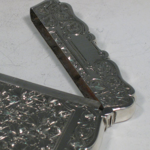 Antique Victorian sterling silver calling card case, having a shaped rectangular body with hand-engraved floral decoration (gingko leaves), and a side-hinged lid. Made in Birmingham in 1879. The dimensions of this fine hand-made silver card case are length 10 cms (4 inches), width 7 cms (2.75 inches), and it weighs approx. 60g (2 troy ounces).